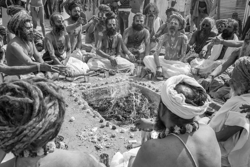 Rāmānandī holymen performing the saṁkalpa ritual prior to the commence of dhūni-tap, fire penance or religious austerity – tapasya and yoga. This photograph was taken by Prema Goet during the Kumbha Mela in Allahabad, India, in 2018/2019, and printed at Fotoleutner in Vienna in 2026. It was acquired by Task Force 3 of the MANTRAMS project as part of Goet’s doctoral research at the University of Vienna. Between 2025 and 2028, the photograph was exhibited within the exhibition “Dhun / Dhūnī.The Fires of the Name,” presented during the Yoga Darśana Conference “Yoga Darśana, Yoga Sādhana: Authenticity, Authority, and Adaptation” in Paris, as well as in an exhibition at the Department of South Asian, Buddhist and Tibetan Studies at the University of Vienna in 2026.